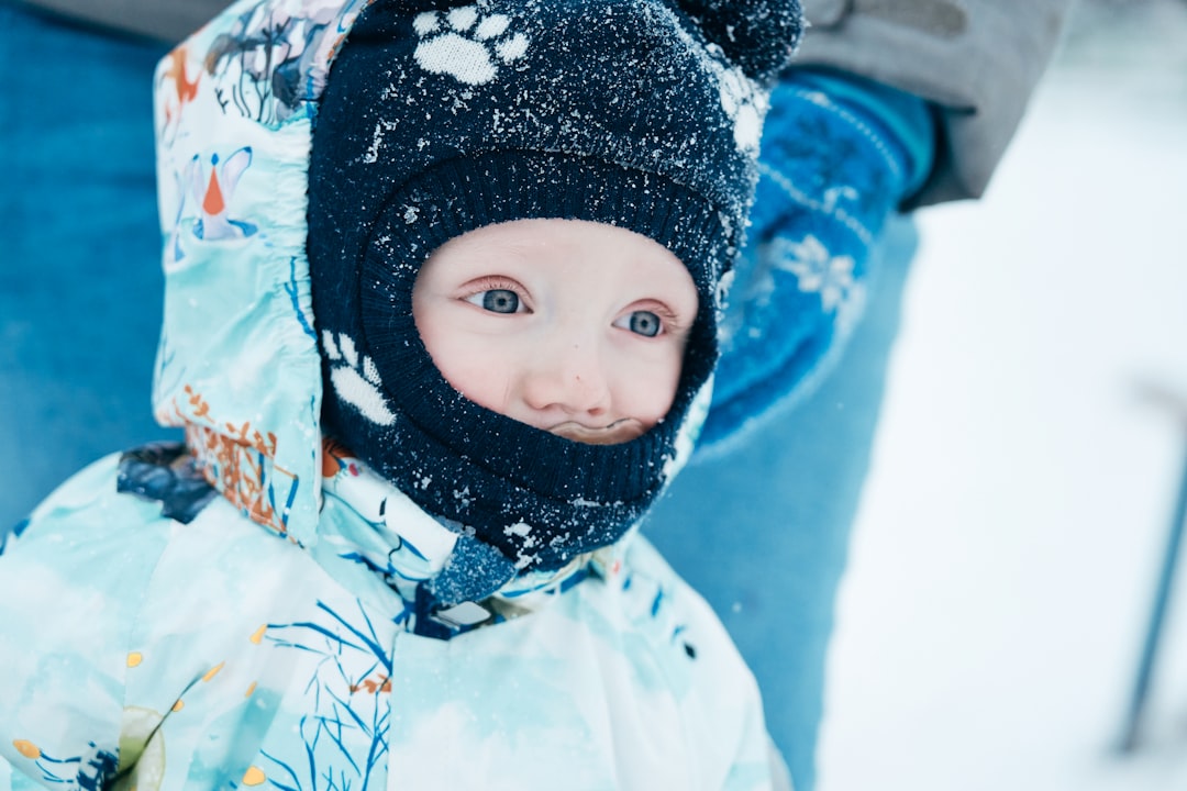 child in blue and white snow jacket