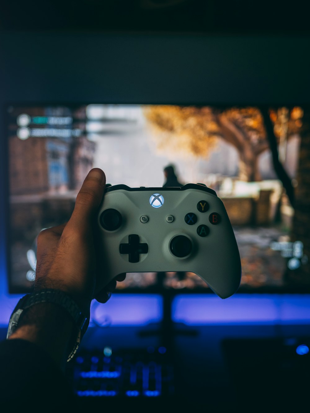 Persona sosteniendo el mando blanco de Xbox One