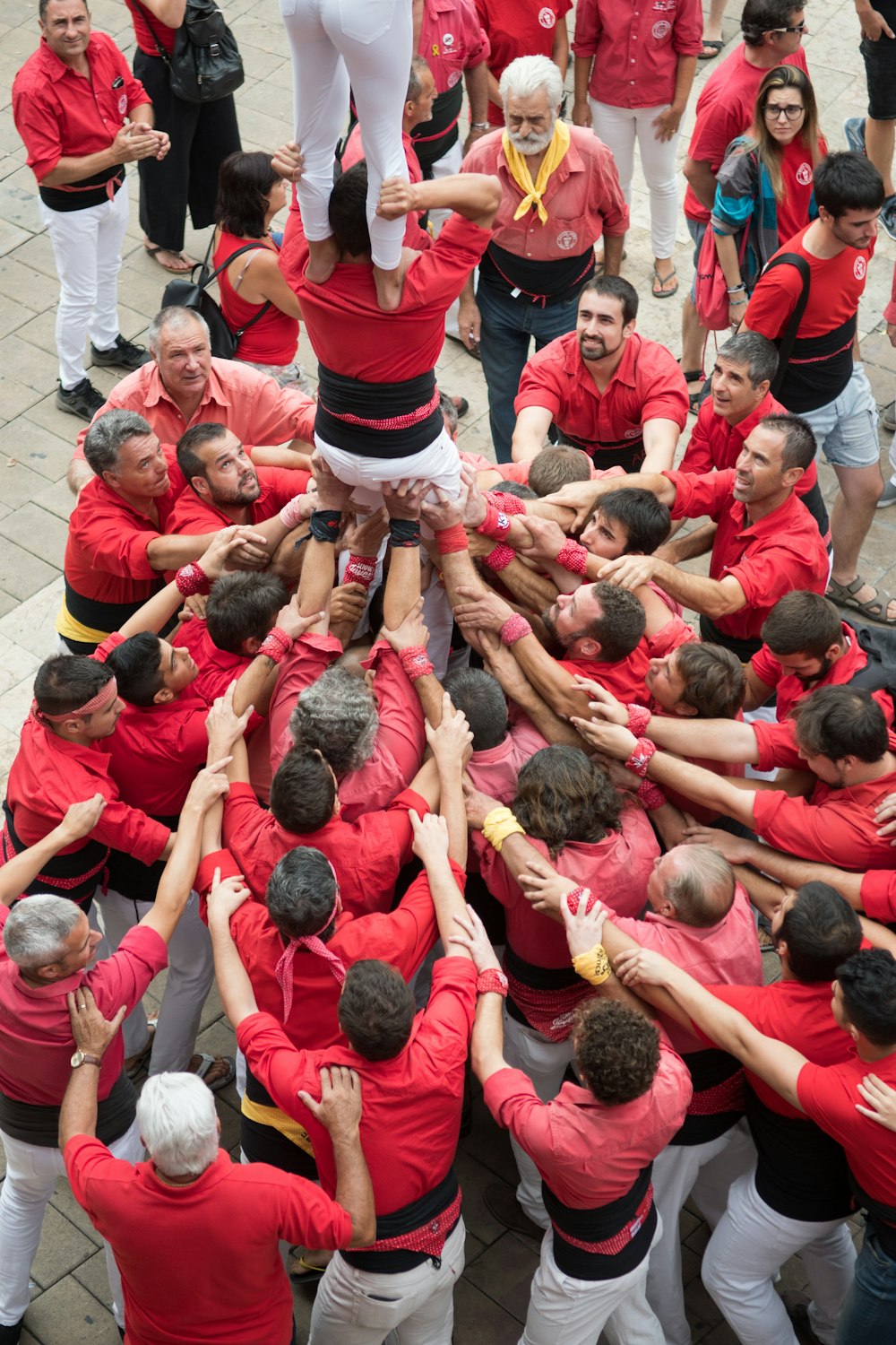 people in red t-shirt lying on white floor tiles