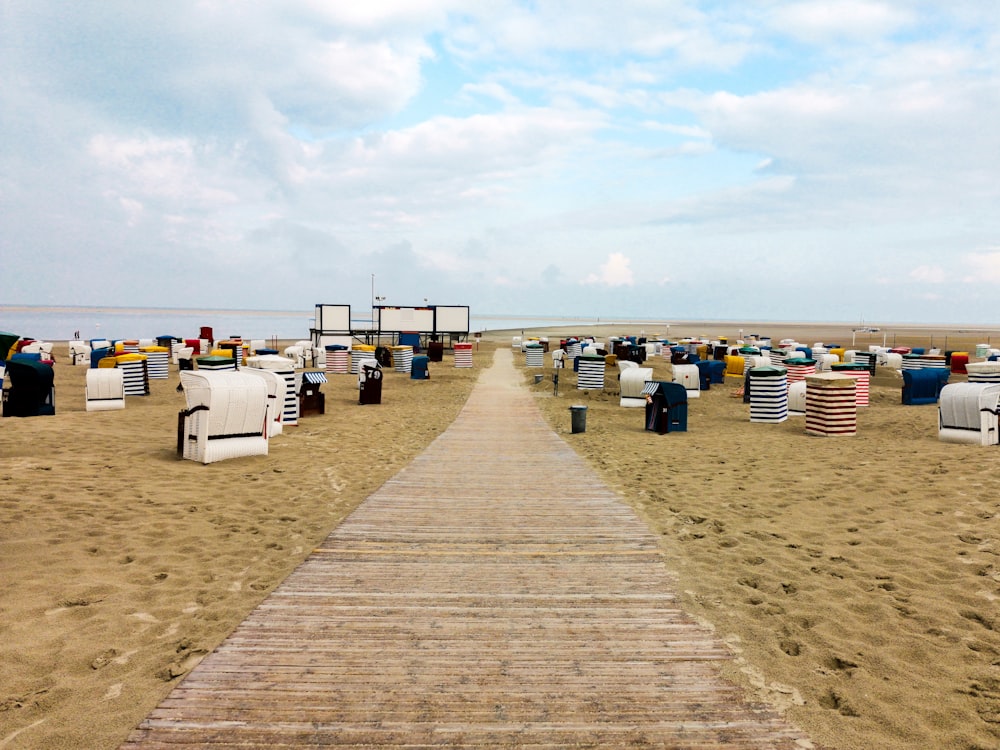 white and blue beach chairs on beach during daytime