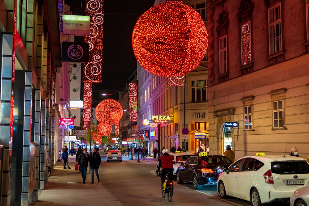 people walking on sidewalk with red heart balloon