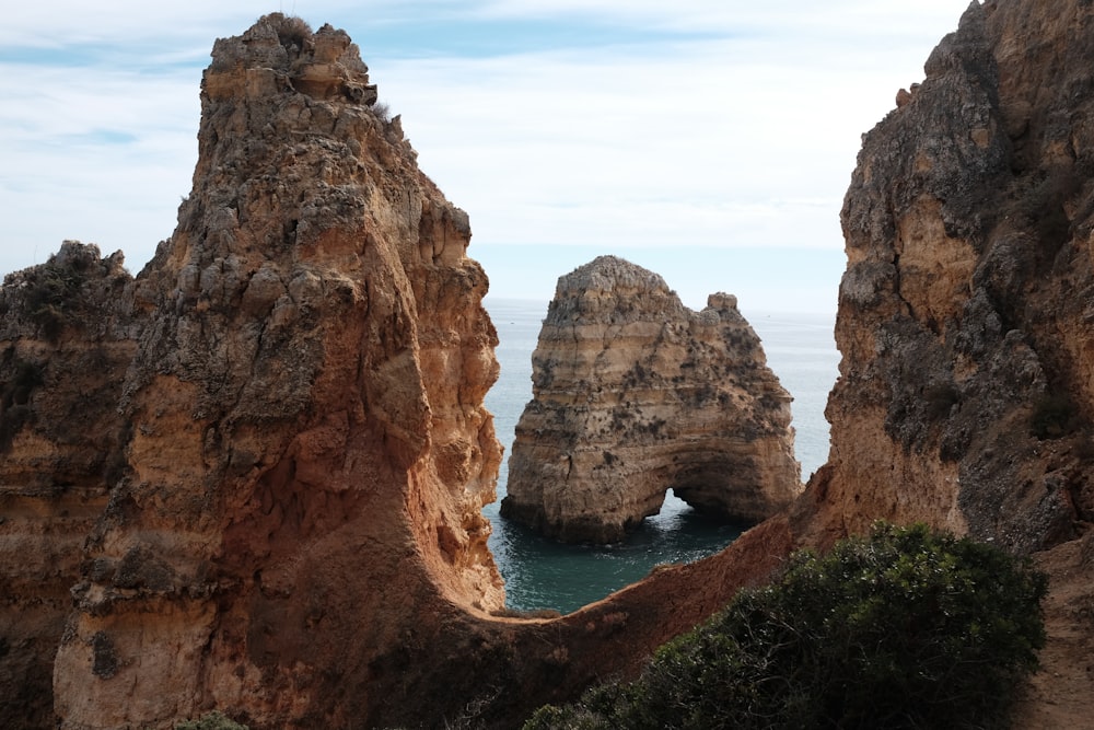 brown rock formation near body of water during daytime