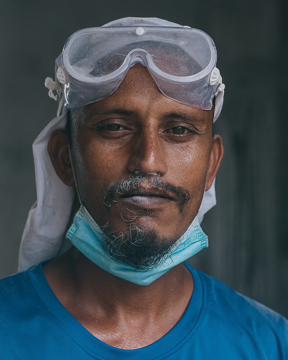 man in blue crew neck shirt with white face mask