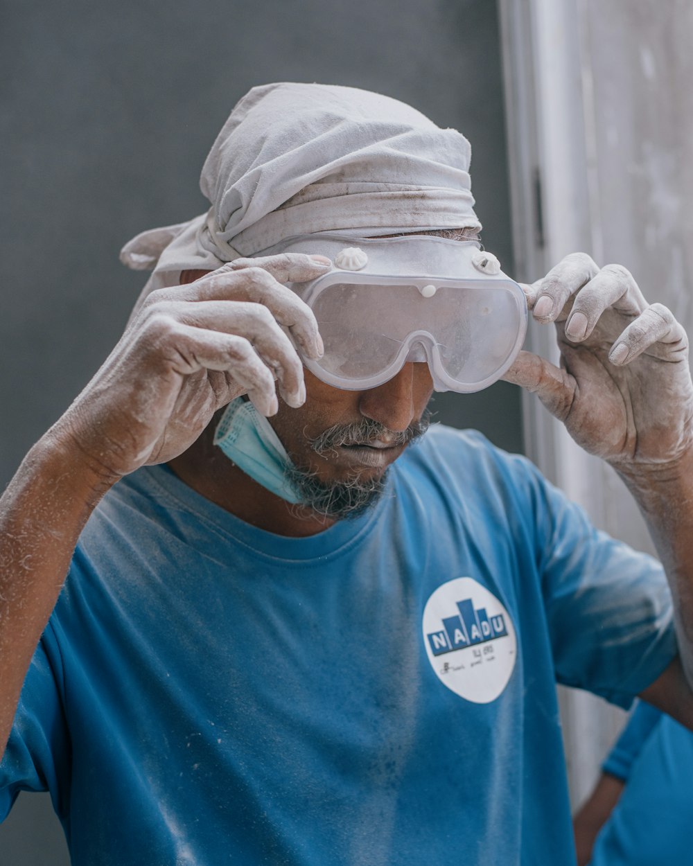 man in blue crew neck t-shirt with white face mask