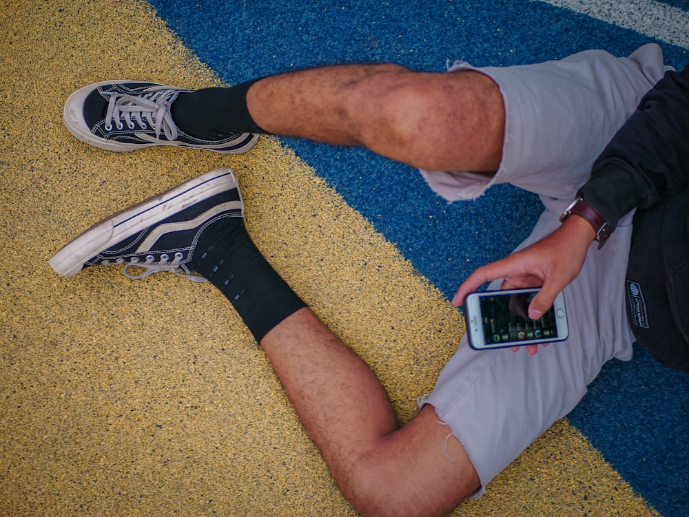 person in white shorts and black and white nike sneakers