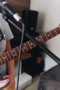 A close-up of a guitar and microphone on stage.