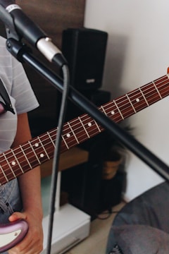 A close-up of a guitar and microphone on stage.