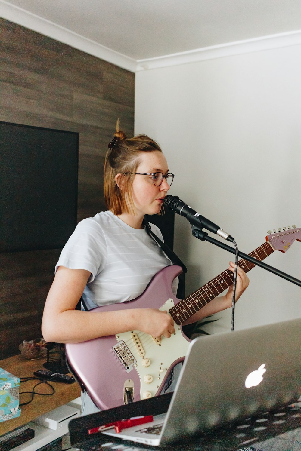 woman in white crew neck t-shirt playing white electric guitar