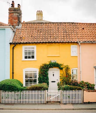 Charming cottage with a white picket fence and blooming flowers.