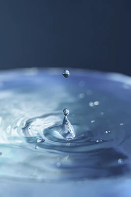 A serene water droplet falling into a clear blue pool symbolizing purity and trust.