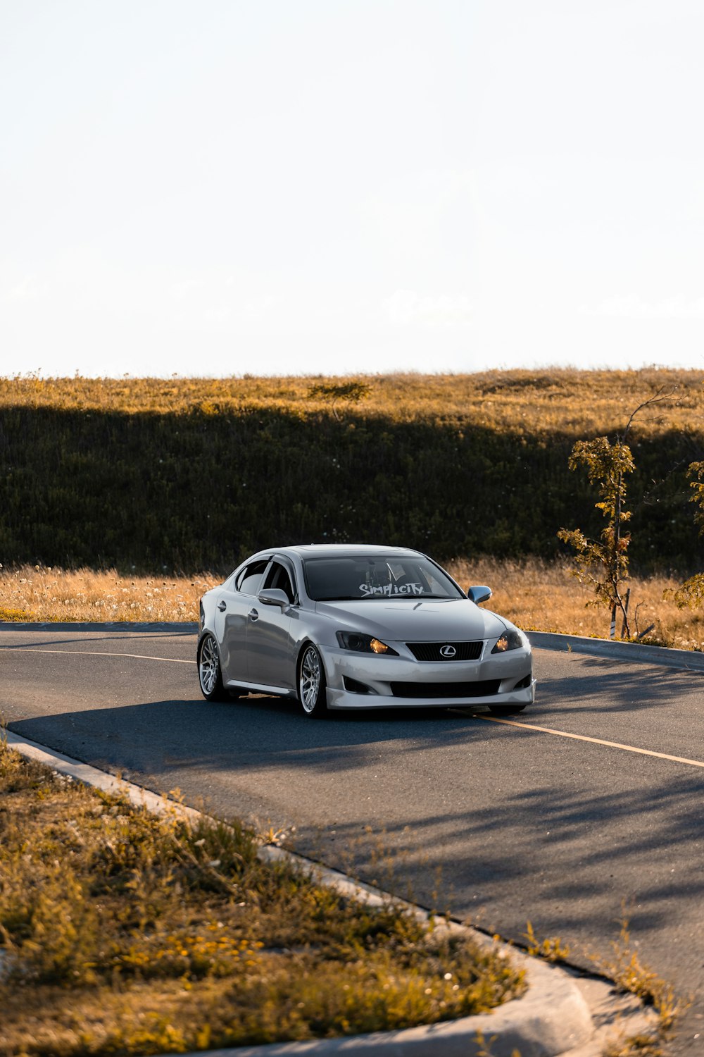 white sedan on gray asphalt road during daytime