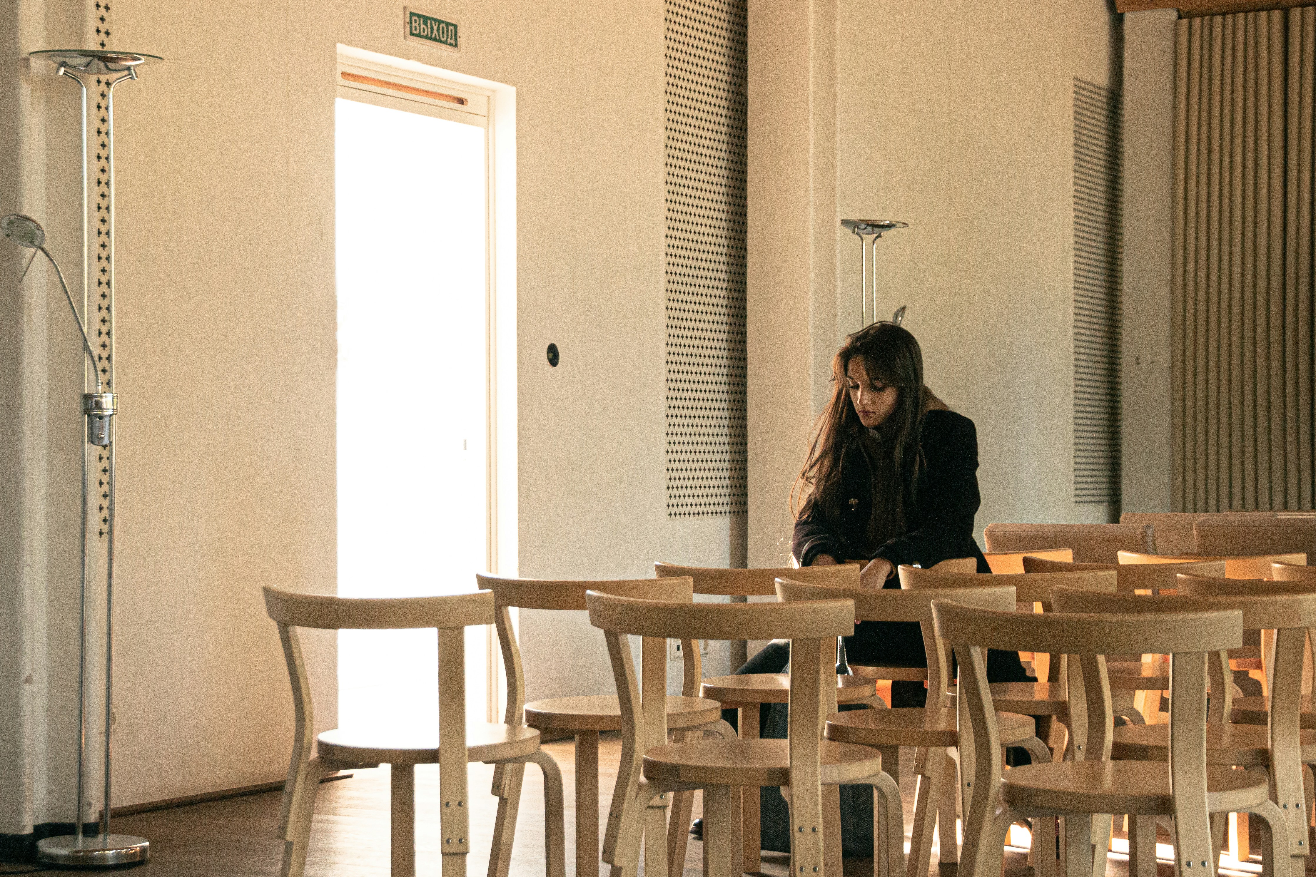 Woman sitting apart from others, symbolising isolation and the loss of outside emotional support in a narcissistic relationship