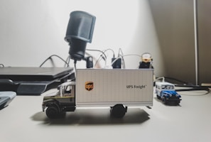 Close-up of a ledger beside a model semi-truck on a desk.