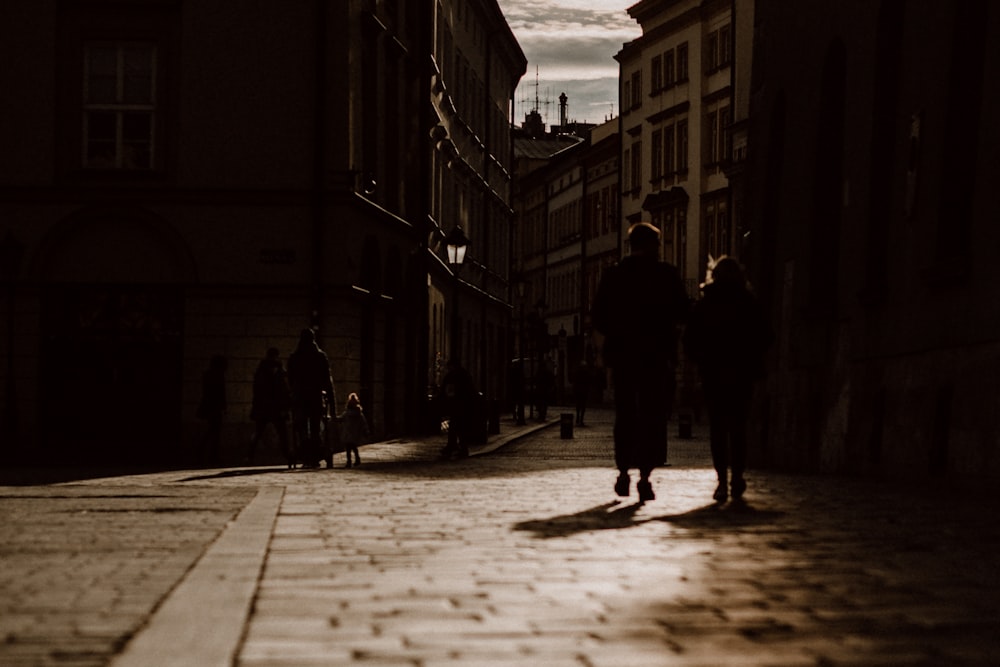 silhouette of man and woman walking on street during daytime