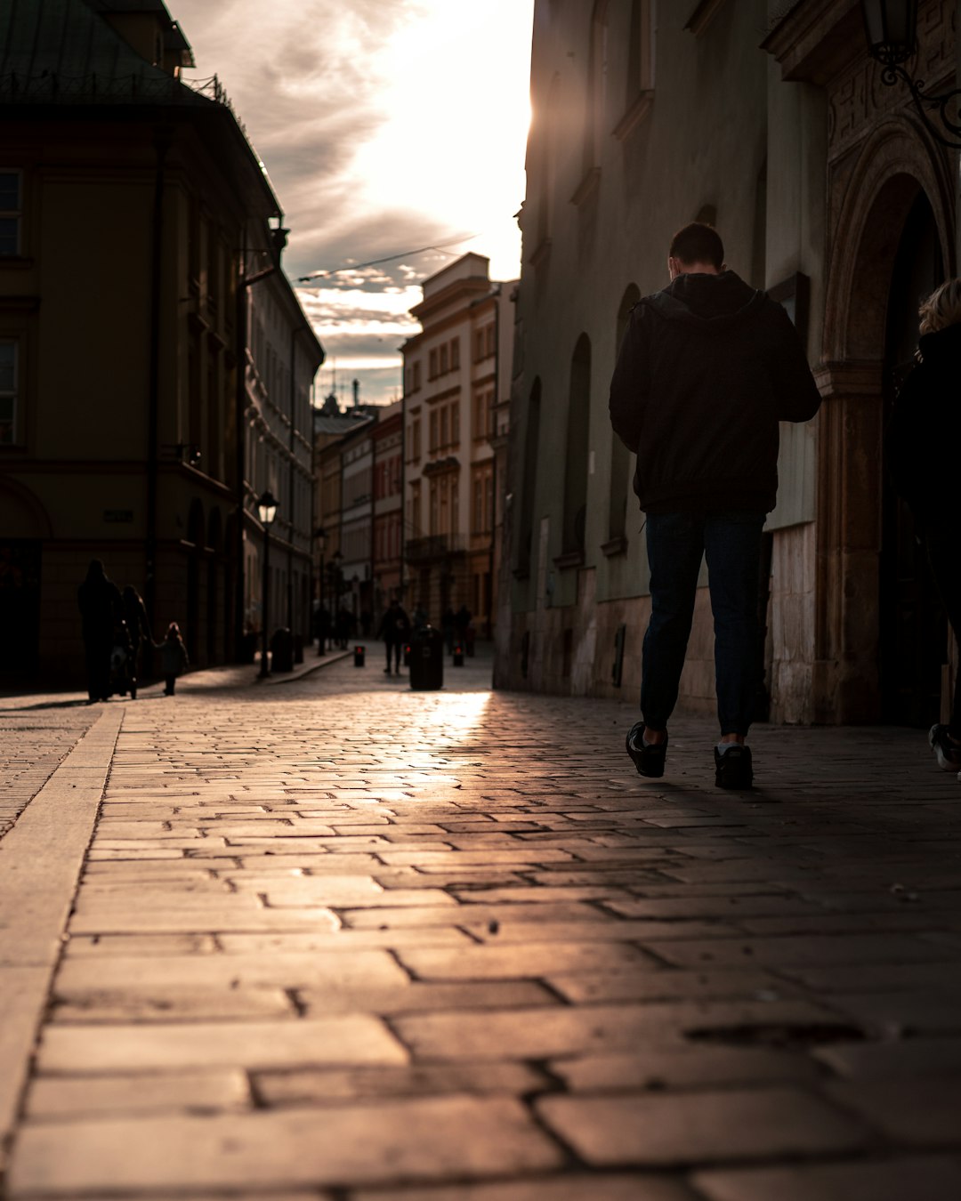 man in black jacket walking on sidewalk during daytime