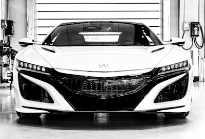 A sleek sports car parked inside a garage with tools and diagnostic equipment around.