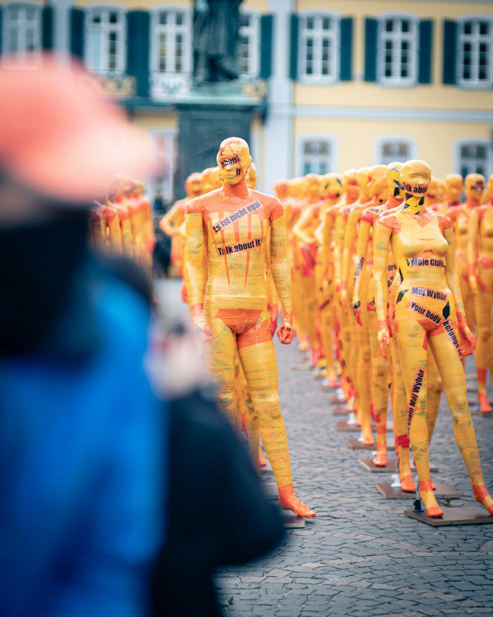 Persone in abito tradizionale blu e giallo che camminano per strada durante il giorno