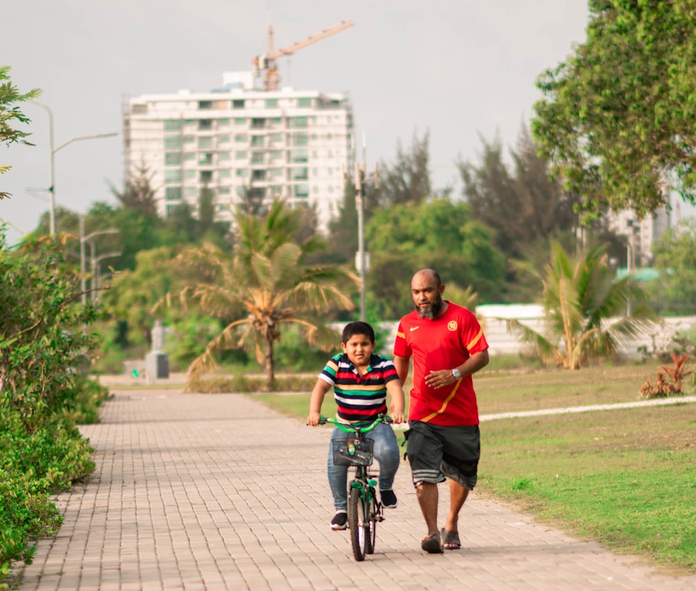man in red shirt riding bicycle during daytime