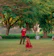 Smiling toddler wearing a colorful boutique dress, playing in a sunlit park.