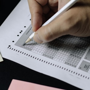 personne qui écrit sur du papier blanc