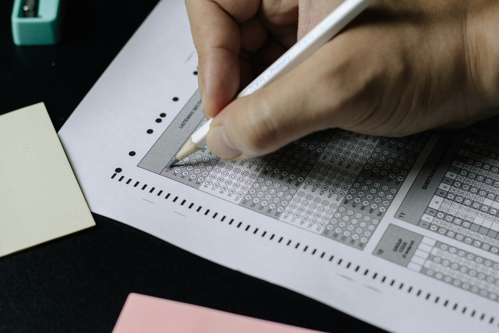 Student filling out standardized test answer sheet with pencil