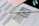 A standardized test answer sheet with multiple-choice bubbles is accompanied by a pencil and a pencil sharpener. Overlapping sheets with filled and unfilled circles indicate test preparation or completion. Colored sticky notes are placed nearby, suggesting organization or note-taking.