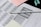 A standardized test answer sheet with multiple-choice bubbles is accompanied by a pencil and a pencil sharpener. Overlapping sheets with filled and unfilled circles indicate test preparation or completion. Colored sticky notes are placed nearby, suggesting organization or note-taking.