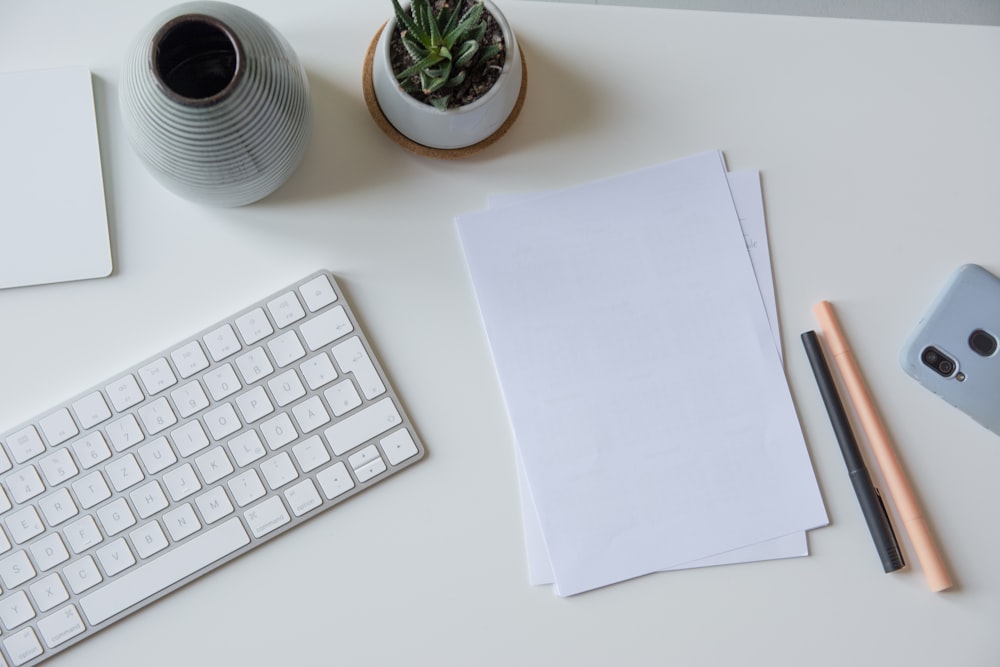 papier d’imprimante blanc à côté du clavier Apple blanc