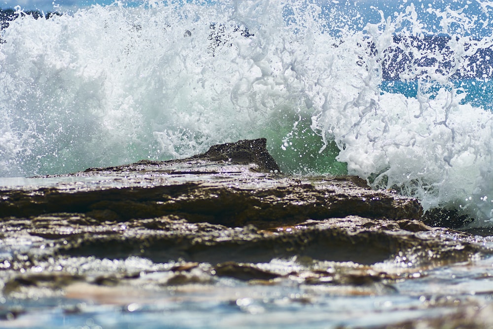 water waves hitting brown rock