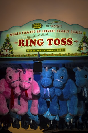 Children laughing while playing a ring toss game at a carnival.