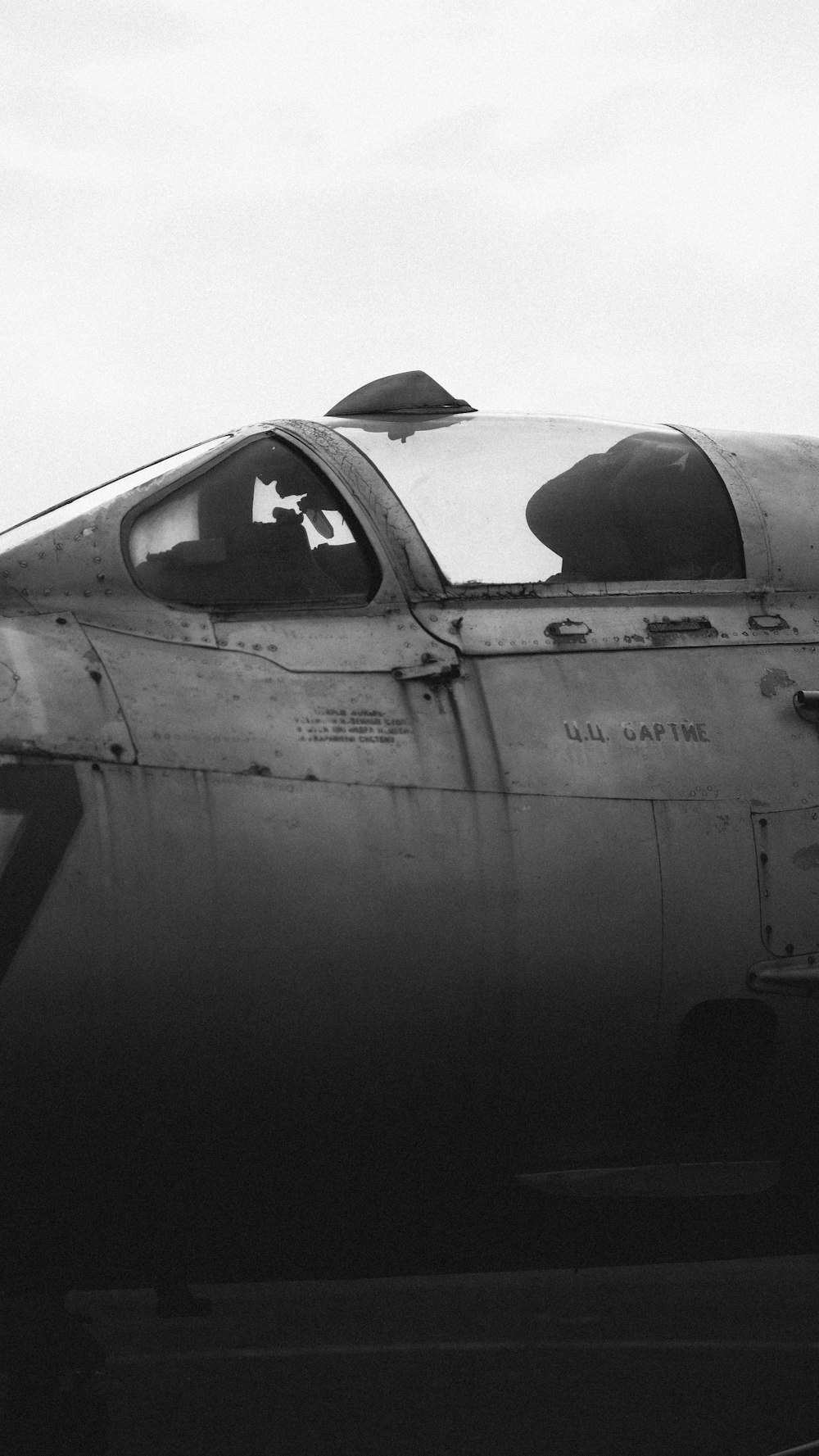 grayscale photo of airplane under cloudy sky