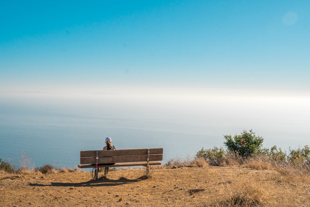 man and woman sitting on brown wooden bench