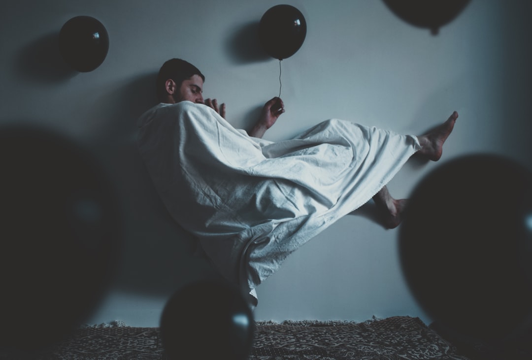 man in white robe sitting on black leather armchair