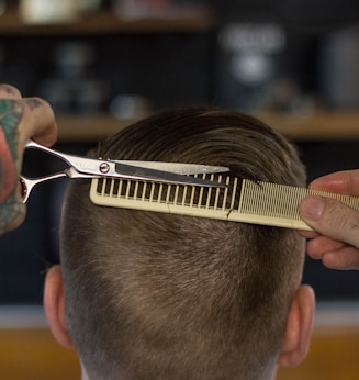 person holding white and gold hair comb