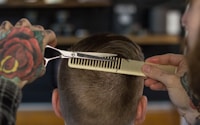 person holding white and gold hair comb