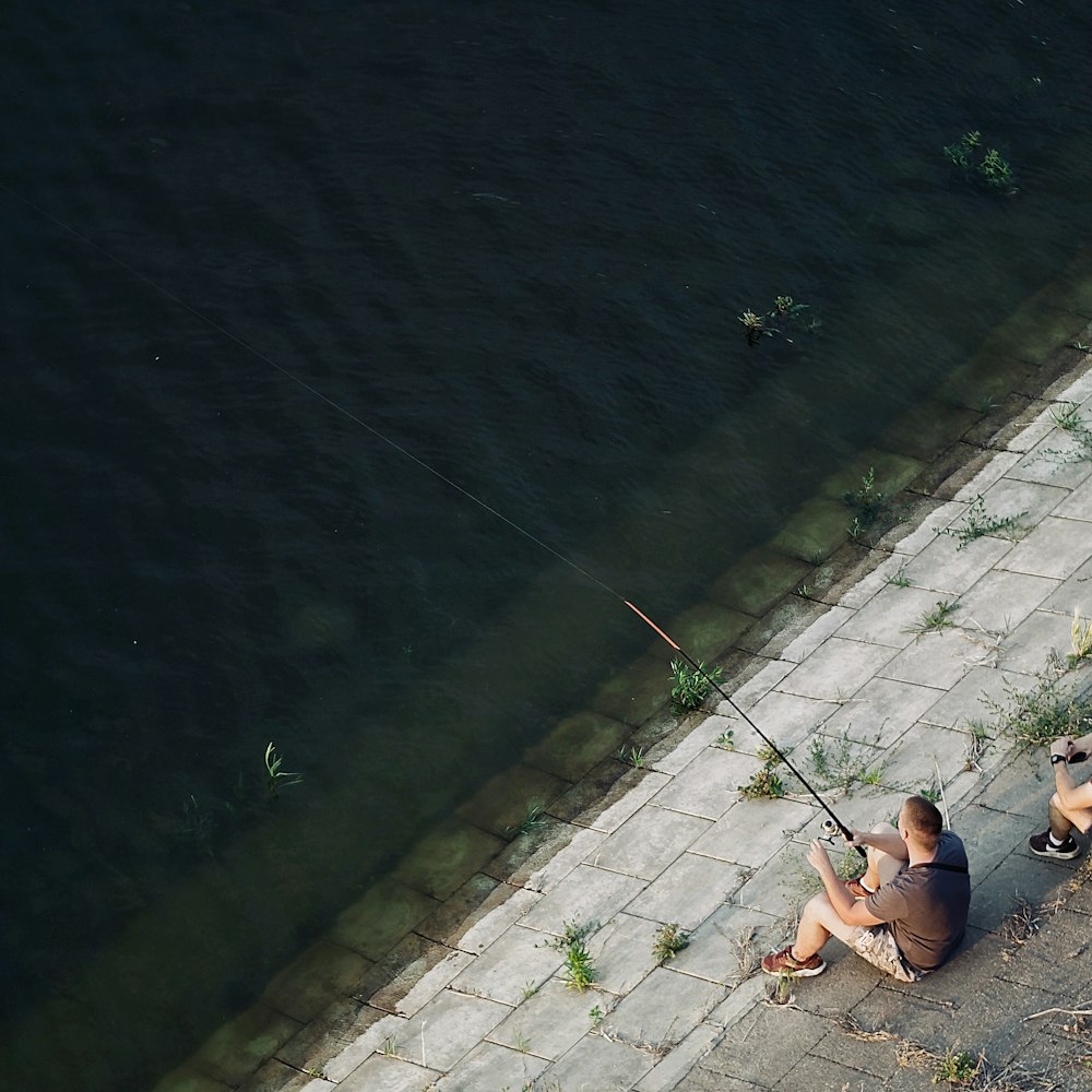 woman in black bikini sitting on gray concrete floor