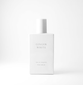A minimalistic and elegant white perfume bottle with 'Ginger White' inscribed on its front. The design is simple with sharp edges, and the text below reads 'Eau de Toilette, 50ml 1.69FL.OZ'. The background is also white, creating a clean and modern look.