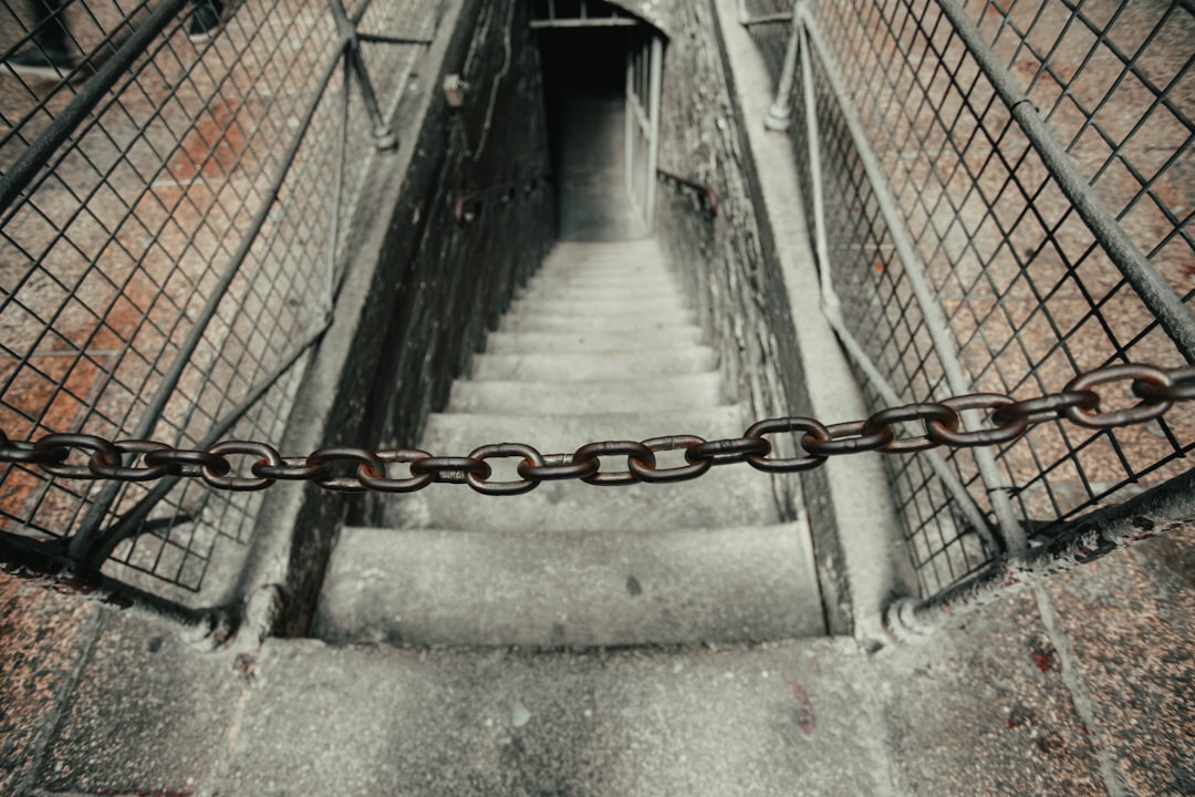 grey metal chain link fence on grey concrete pathway