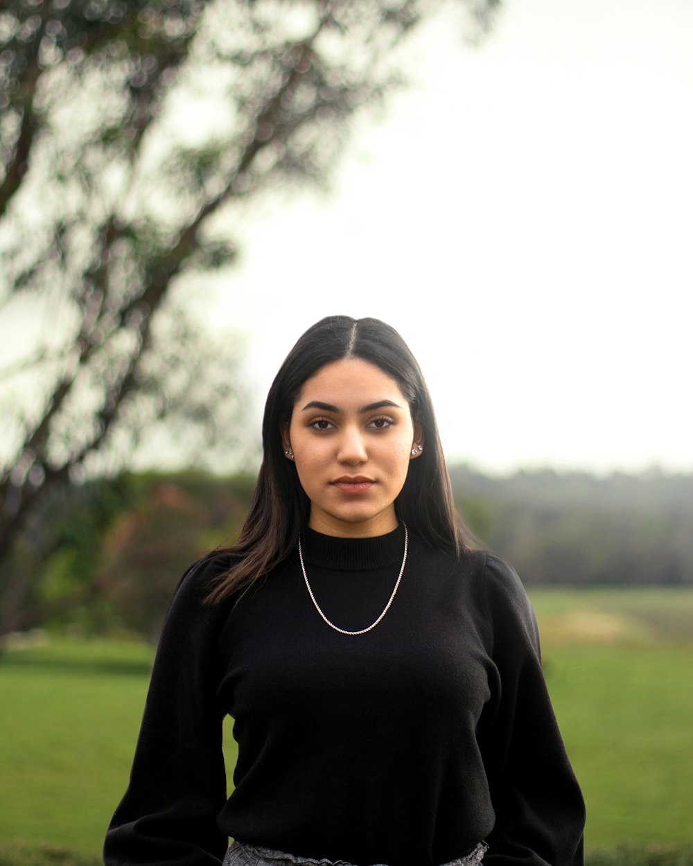 woman in black turtleneck long sleeve shirt standing on green grass field during daytime