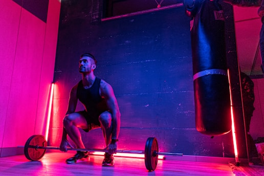 A dynamic man lifting weights in a neon green-lit gym environment.