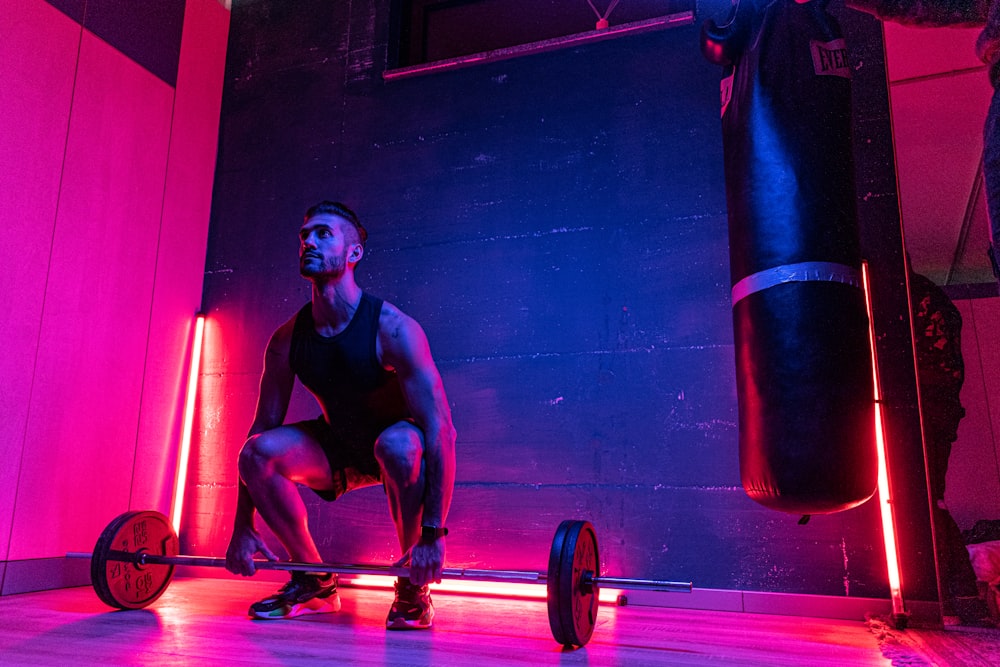 Mann in schwarzem Tanktop und blauen Shorts beim Sport