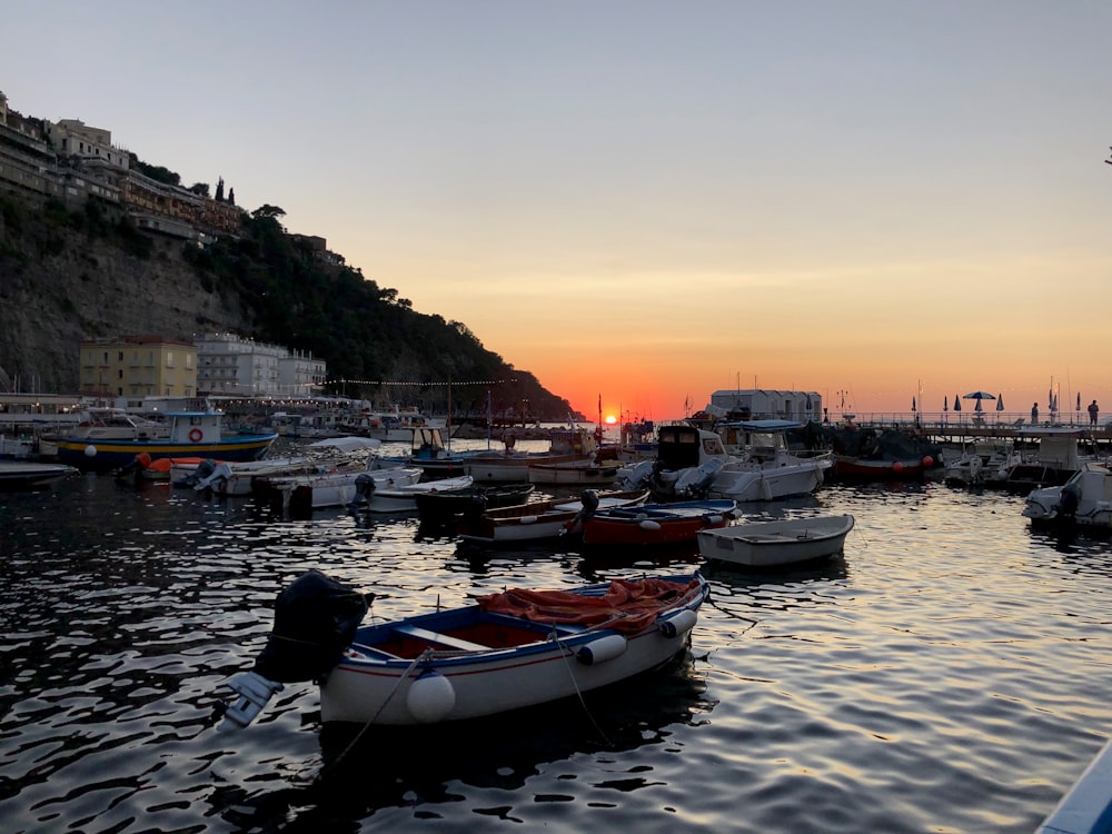 Barco blanco y rojo en el mar durante la puesta del sol
