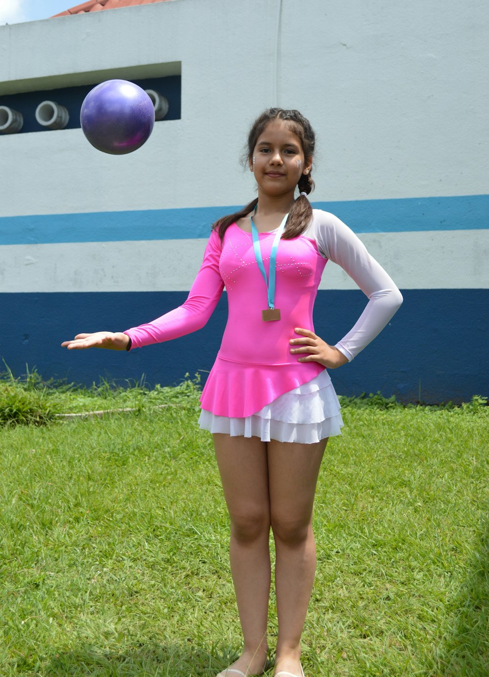 woman in pink long sleeve shirt and white skirt standing on green grass field during daytime