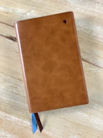 The nightingale logo subtly embossed on a leather-bound course booklet resting on a desk.