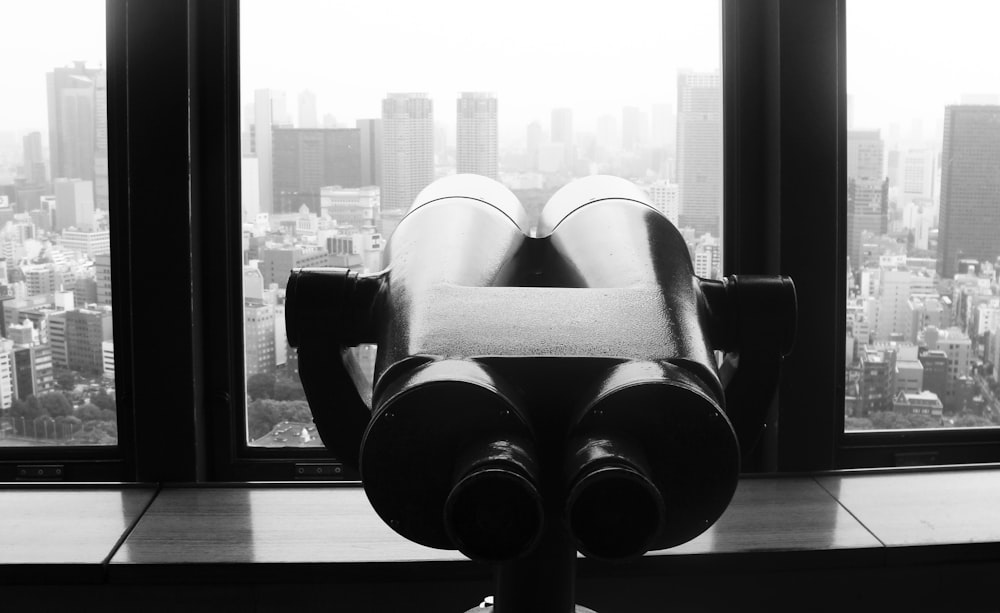 gray binoculars on glass window