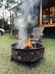 Outdoor fire pit area near the cabin with Adirondack chairs ready for evening gatherings.
