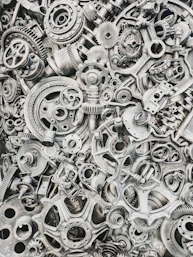 A dense collection of assorted metal gears, cogs, and mechanical machine parts
