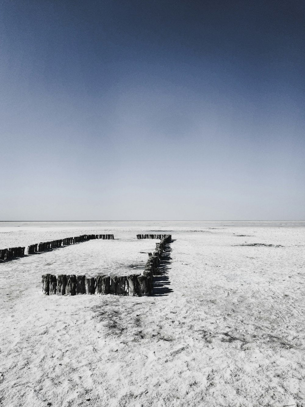 a black and white photo of a bench in the snow