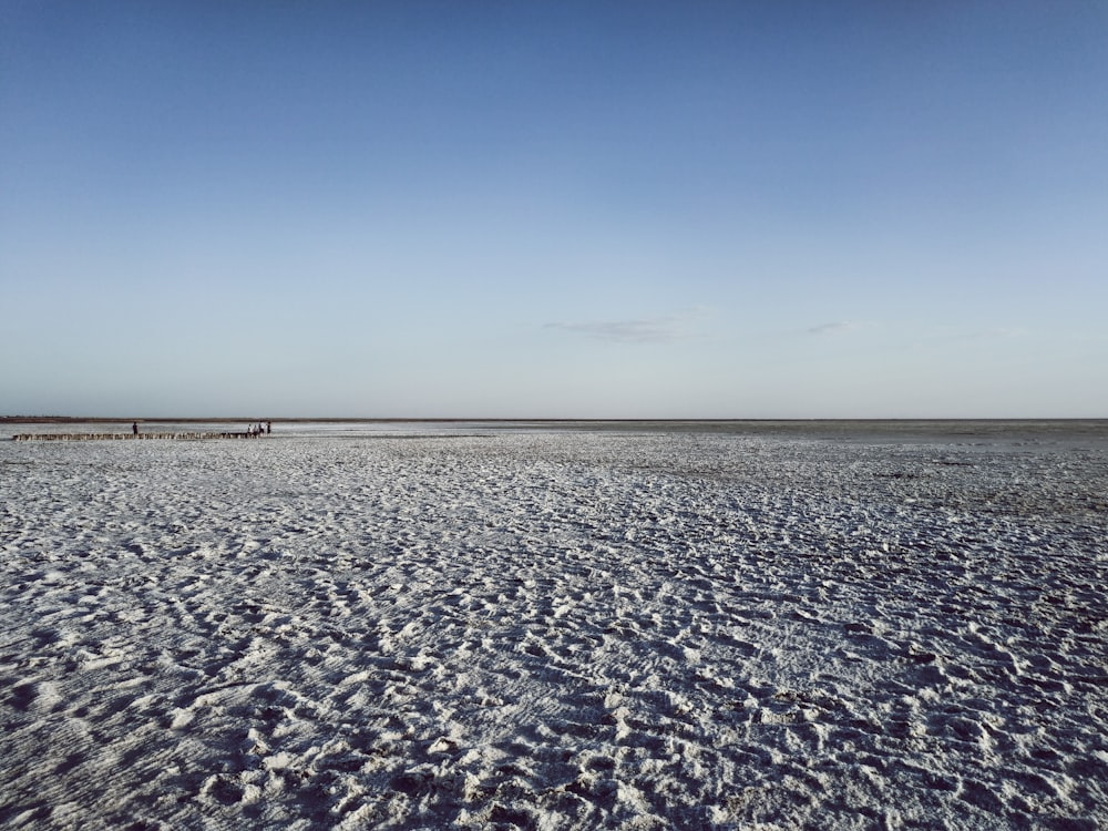 a beach covered in snow under a blue sky