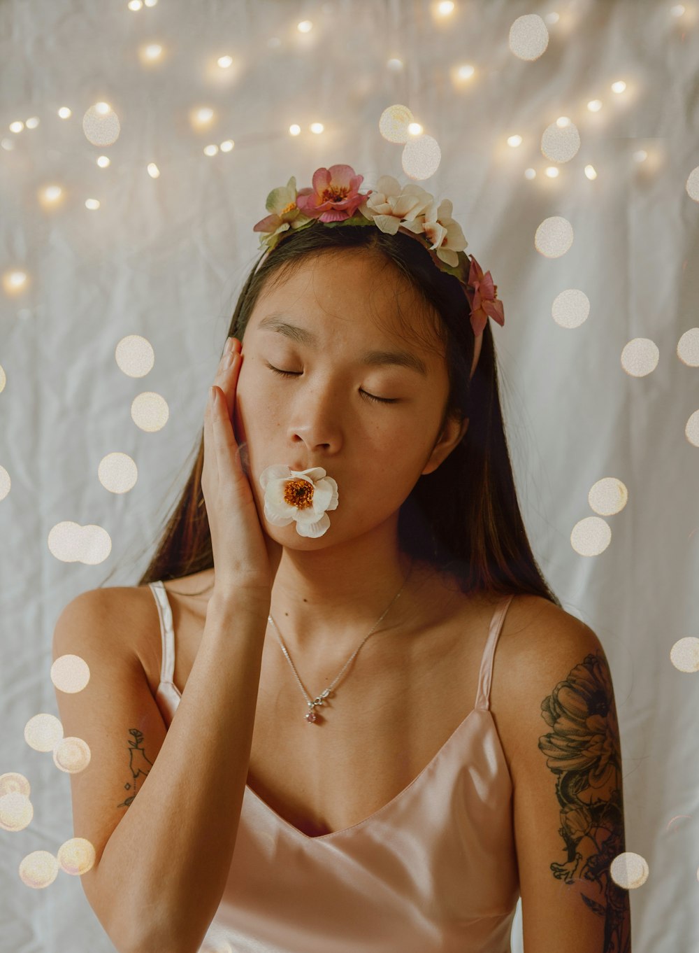 woman in white tank top with white and pink flower on her ear